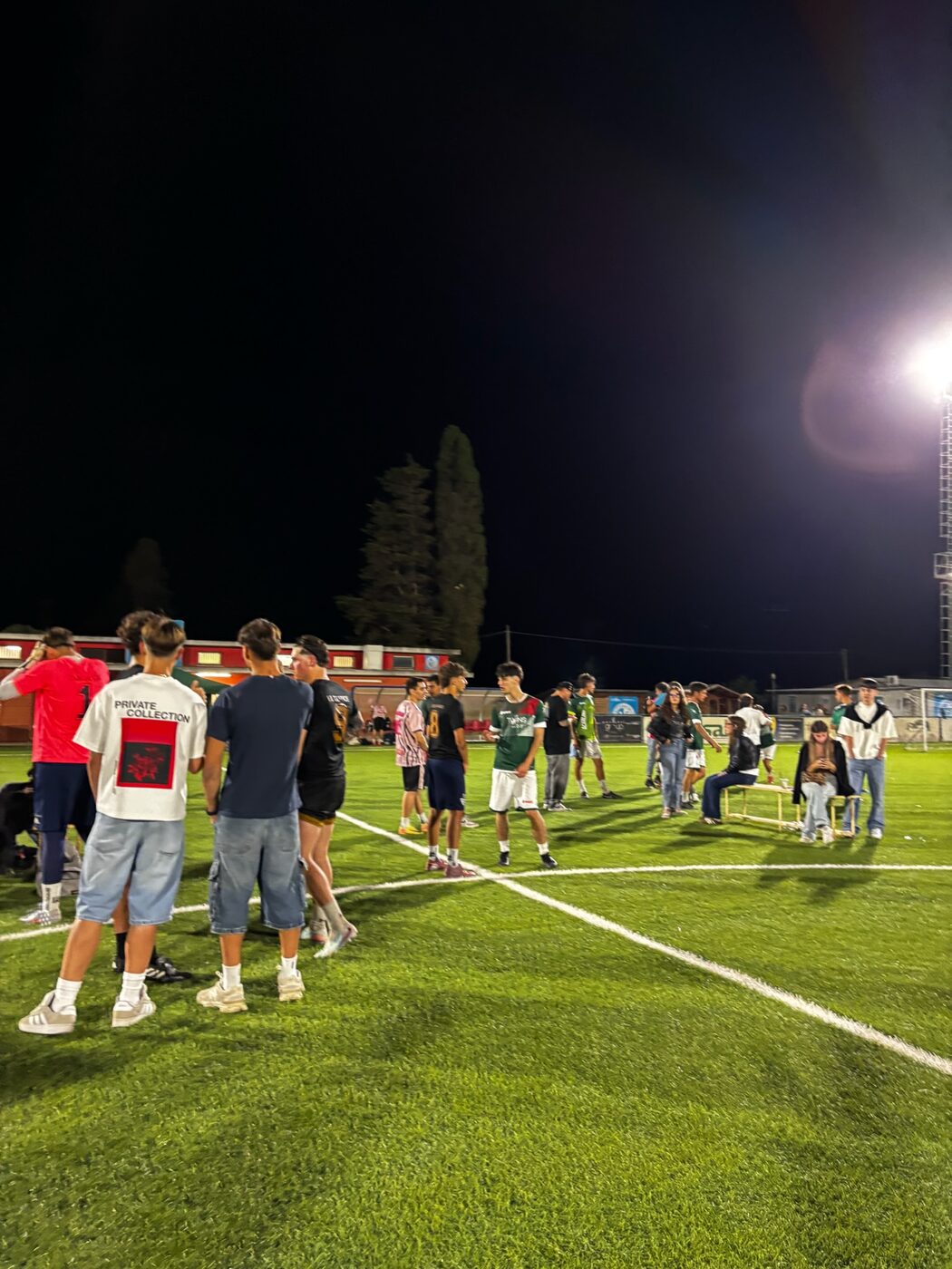 Giocatori e pubblico in campo di sera